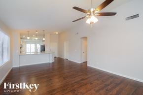 Surprise house for rent - A spacious room with a ceiling fan and wooden flooring.