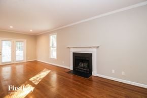 Greensboro house for rent - A large empty room with a fireplace and a window.