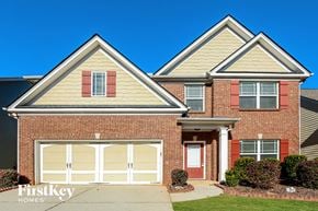 Lawrenceville house for rent - a brick house with two peaked roofs and a white garage door