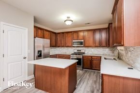 Lawrenceville house for rent - a kitchen with wooden cabinets and a white counter top