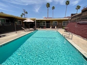 Cathedral City apartment for rent - a swimming pool with an umbrella in front of a house