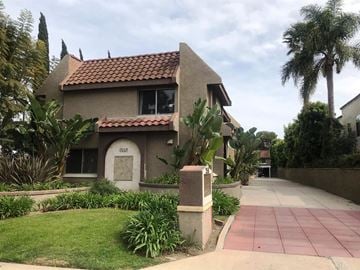 Costa Mesa apartment for rent - A house with a red tile roof and a garden in front.