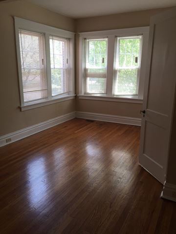 St. Louis apartment for rent - an empty living room with wood floors and three windows