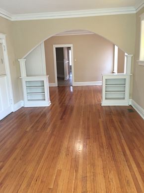 St. Louis apartment for rent - an empty living room with a hard wood floor and a hallway with two dressers