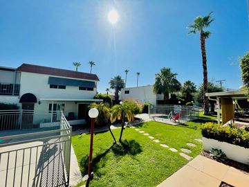 Palm Desert apartment for rent - a house with a lawn and palm trees in front of it