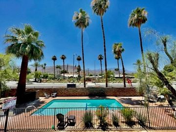 Palm Desert apartment for rent - a swimming pool with palm trees in the background