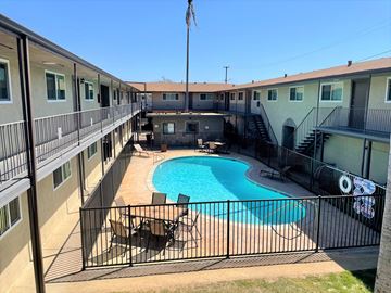 Anaheim apartment for rent - A black fence surrounds a small pool in a courtyard.