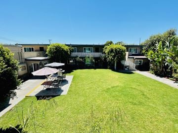 Anaheim apartment for rent - a backyard with a lawn and tables and umbrellas