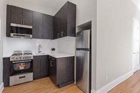 Brooklyn apartment for rent - a kitchen with stainless steel appliances and black cabinets