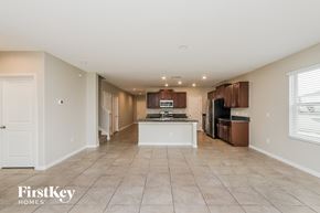 Riverview house for rent - A spacious kitchen and living room with white walls and tile flooring.