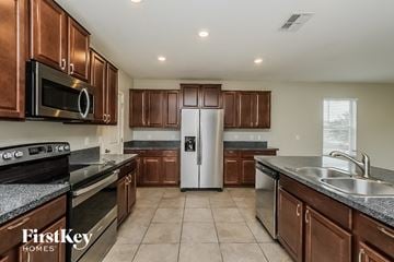 Riverview house for rent - A kitchen with brown cabinets and a stainless steel refrigerator.