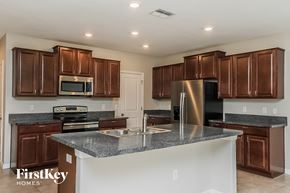 Riverview house for rent - A kitchen with brown cabinets and a stainless steel refrigerator.