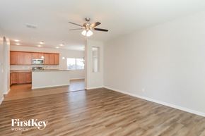 San Tan Valley house for rent - an empty living room and kitchen with a ceiling fan
