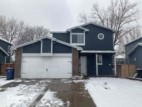 Arvada house for rent - A house with a snow-covered driveway in front.