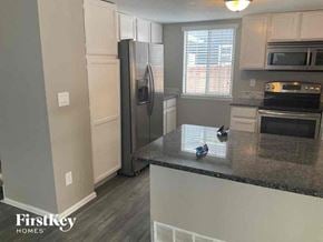 Arvada house for rent - A kitchen with a black fridge and a black stove top oven.