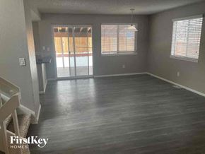 Arvada house for rent - A spacious room with wooden flooring and a sliding glass door.