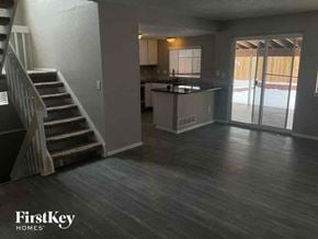 Arvada house for rent - A spacious living room with a staircase on the left and a kitchen area on the right.