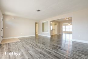 Rotonda West house for rent - the living room and dining room of an empty house with wood flooring