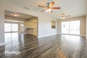 Rotonda West house for rent - an empty living room with wood floors and a ceiling fan