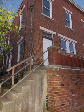 Cincinnati apartment for rent - A red brick building with a white door and windows.