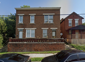 Cincinnati apartment for rent - A brick house with a car parked in front.