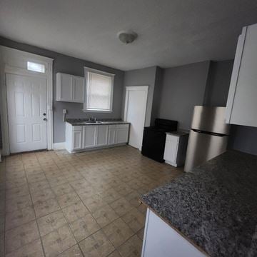 Cincinnati apartment for rent - A kitchen with a granite counter and white cabinets.