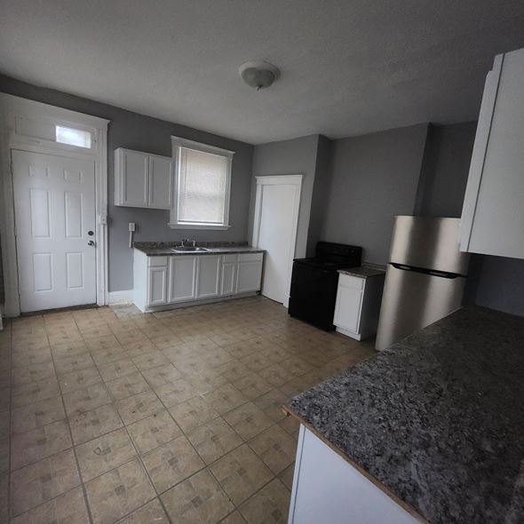 Cincinnati apartment for rent - A kitchen with a granite counter and white cabinets.