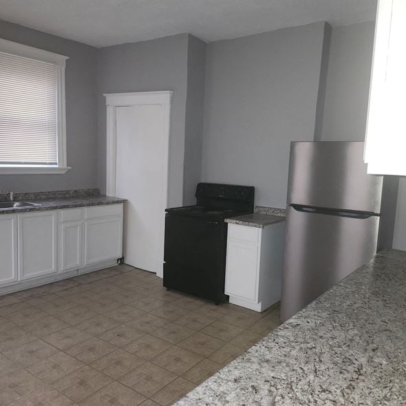Cincinnati apartment for rent - A kitchen with a black dishwasher and a white refrigerator.