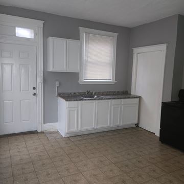 Cincinnati apartment for rent - A kitchen with white cabinets and a marble countertop.