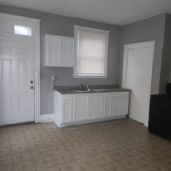 Cincinnati apartment for rent - A kitchen with white cabinets and a marble countertop.