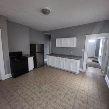 Cincinnati apartment for rent - A kitchen with a black fridge and a black stove.