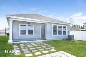 Jacksonville house for rent - the exterior of a small blue house with a yard and grass