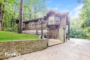 Douglasville house for rent - the front of a house with a driveway and a stone wall