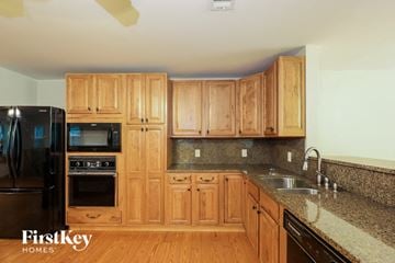 Douglasville house for rent - a kitchen with wooden cabinets and granite counter tops