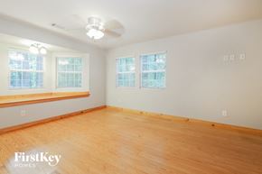 Douglasville house for rent - a living room with a wood floor and a ceiling fan