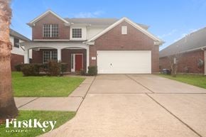 Humble house for rent - A brick house with a red door and a garage door.