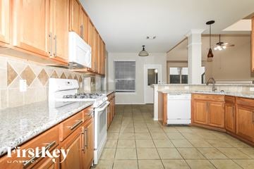 Humble house for rent - A kitchen with wooden cabinets and a white oven.