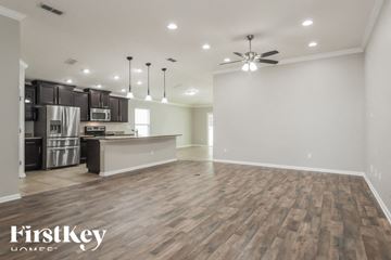 St Johns house for rent - A spacious kitchen with dark wood floors and a ceiling fan.