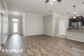 St Johns house for rent - A spacious room with wooden flooring and a kitchen area in the background.