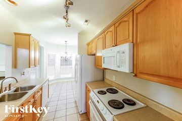 Helena house for rent - A kitchen with wooden cabinets and a white stove top oven.