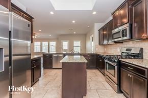 Katy house for rent - a large kitchen with stainless steel appliances and granite counter tops