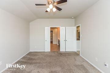 Katy house for rent - a spacious living room with carpet and a ceiling fan