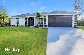 Cape Coral house for rent - a white house with a garage and a lawn