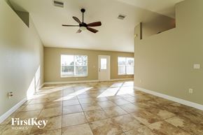 Cape Coral house for rent - an empty living room with tile floors and a ceiling fan