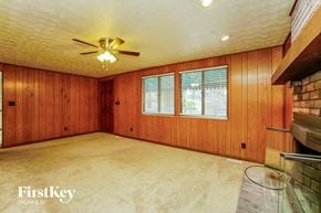 Dublin house for rent - a living room with wood paneling and a ceiling fan