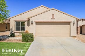 San Tan Valley house for rent - A house with a garage door and a tree in front of it.