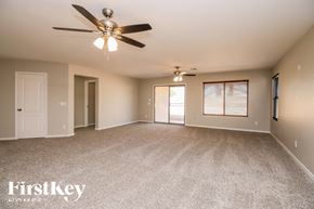 San Tan Valley house for rent - A spacious room with a ceiling fan and carpeted floor.