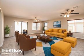 San Tan Valley house for rent - A living room with a brown sofa, two chairs, and a coffee table.
