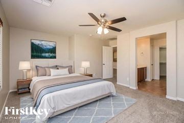 San Tan Valley house for rent - A bedroom with a large bed and a ceiling fan.