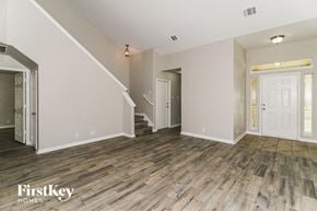 New Braunfels house for rent - A room with wooden floors and a staircase leading to another room.